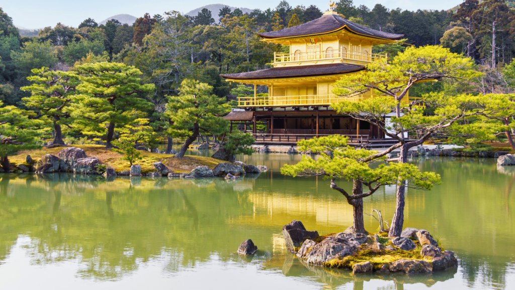 The stunning Kinkaku-ji (Golden Pavilion) in Kyoto, Japan, reflecting on the calm waters of Kyoko-chi Pond. Surrounded by lush greenery and meticulously landscaped gardens, this iconic Zen temple is one of Kyoto’s most famous and picturesque landmarks.