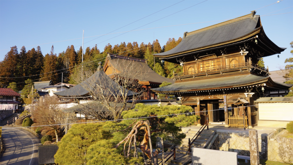 Traditional wooden temple in Takayama, Japan, surrounded by lush greenery and historic architecture in the Japanese Alps.