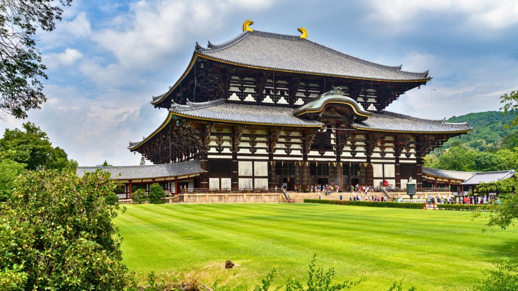 The Great Buddha Hall (Daibutsuden) of Todai-ji Temple in Nara, Japan, a majestic wooden structure housing the world’s largest bronze Buddha statue, surrounded by lush greenery.