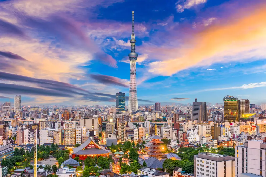 Stunning skyline of Tokyo, Japan, featuring the iconic Tokyo Skytree at sunset with a vibrant cityscape and historic Senso-ji Temple in the foreground.