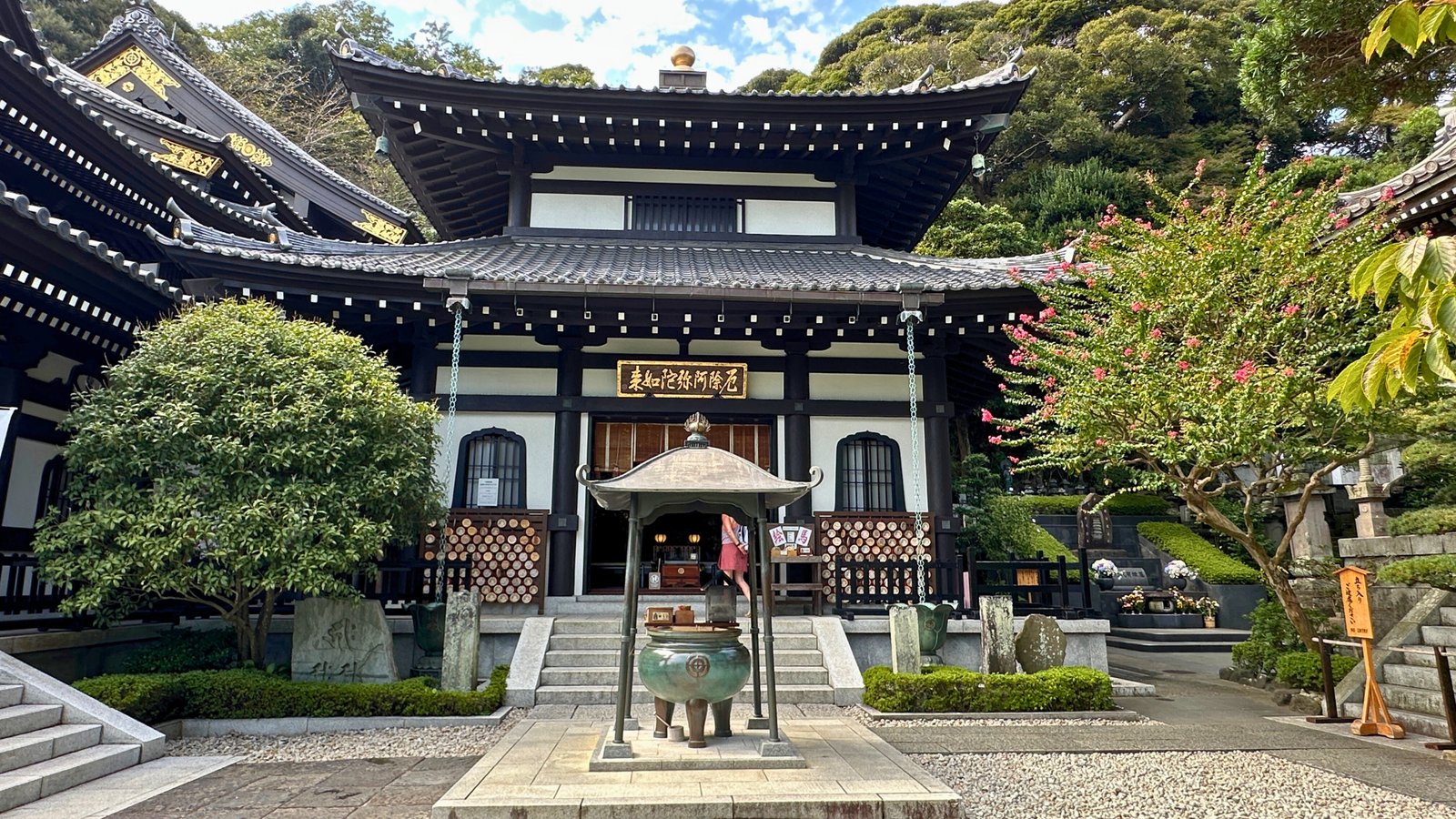 Hase-dera Temple in Kamakura, Japan Hase-dera Temple in Kamakura, surrounded by lush greenery and featuring traditional wooden architecture, a prayer incense burner, and a peaceful courtyard.