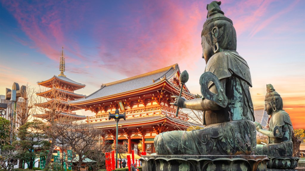 Senso-ji Temple in Asakusa, Tokyo at sunset with bronze statues in the foreground
