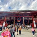 Tourists and locals at Senso-ji Temple in Tokyo, Japan, a historic Buddhist temple known for its vibrant red architecture, large lantern, and cultural significance.