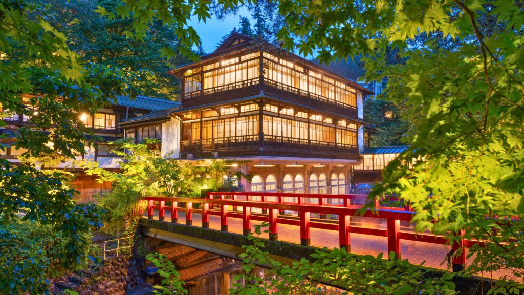 Traditional ryokan with glowing lights at dusk in Shima Onsen, Gunma, Japan