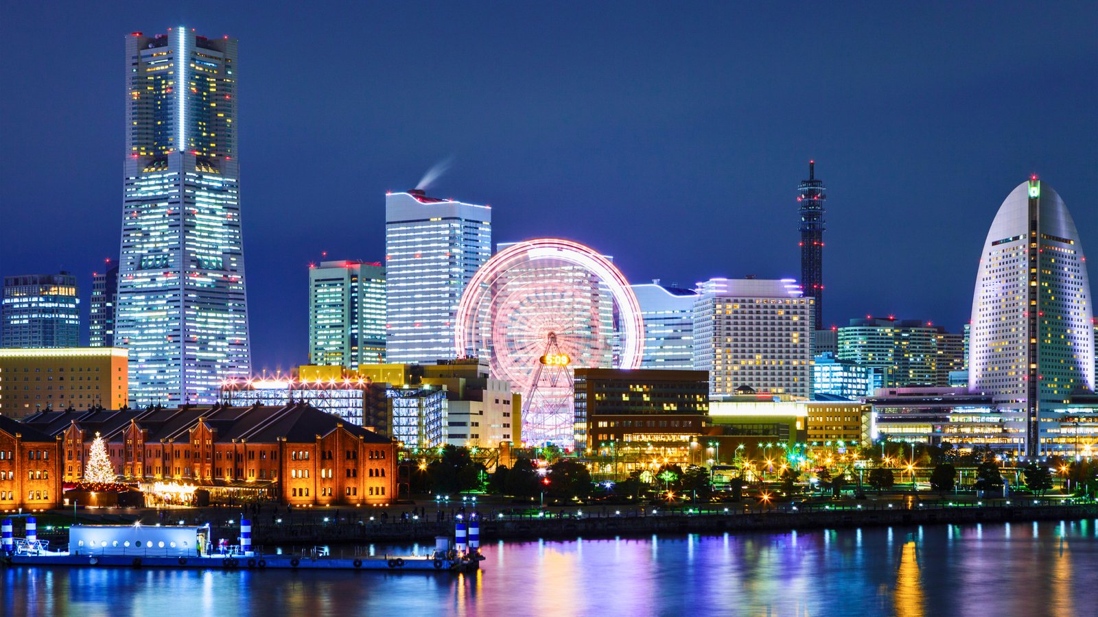 Yokohama, Japan The illuminated Yokohama skyline at night, featuring the Landmark Tower, Cosmo Clock 21 Ferris wheel, and the modern waterfront district reflecting on the bay.